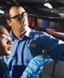 Two mechanics look up into a vehicle