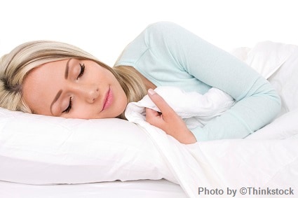 M7A A woman asleep in bed with her head on a pillow