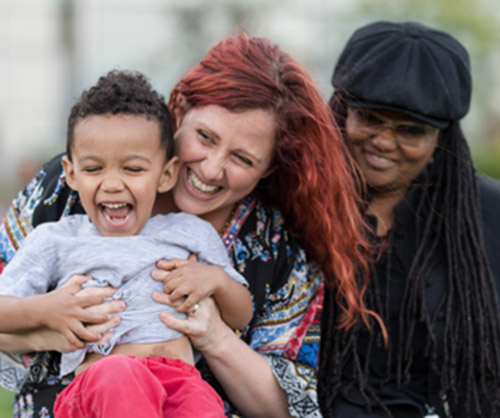 Two women and a child smiling