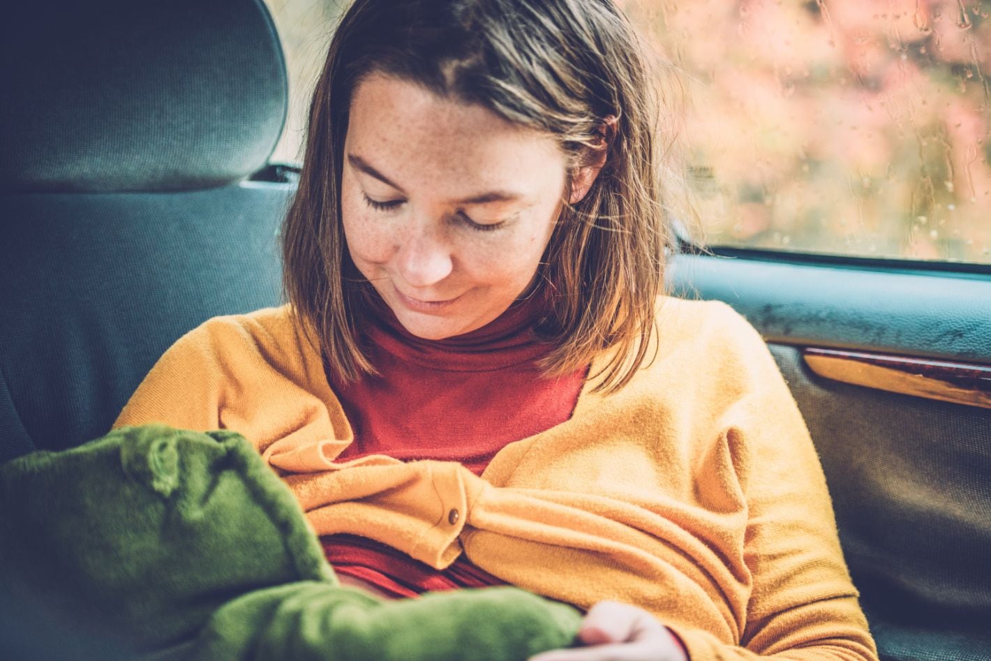 Breastfeeding-in-car Una mujer amamantando a su bebé en un coche.