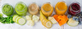 food-drinks-to-encourage Assorted fruits and vegetables cut up into chunks, placed by small jars containing pureed versions of the same food.