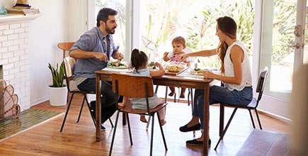 A young couple and their toddler son interacting during a meal. 