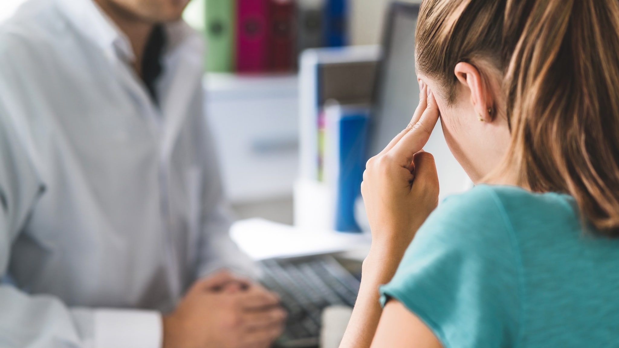 Sick person and healthcare provider Photo of a person who has a headache talking to their healthcare provider.
