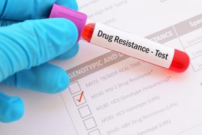 drug-resistance-test The form shows a test ordered for HIV-1 Drug Resistance. A gloved hand holds a blood sample collection vial with a “drug resistance test” label.