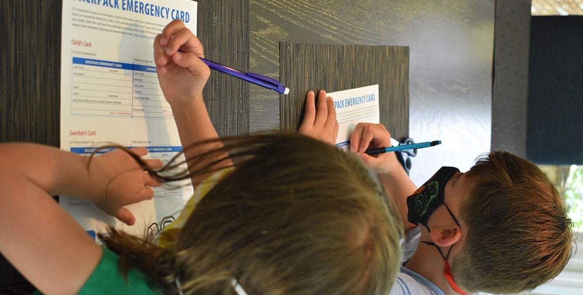 Siblings filling out an emergency backpack card