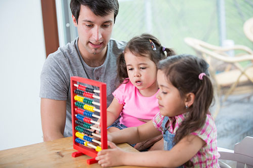 Padre con sus hijas jugando con un juguete