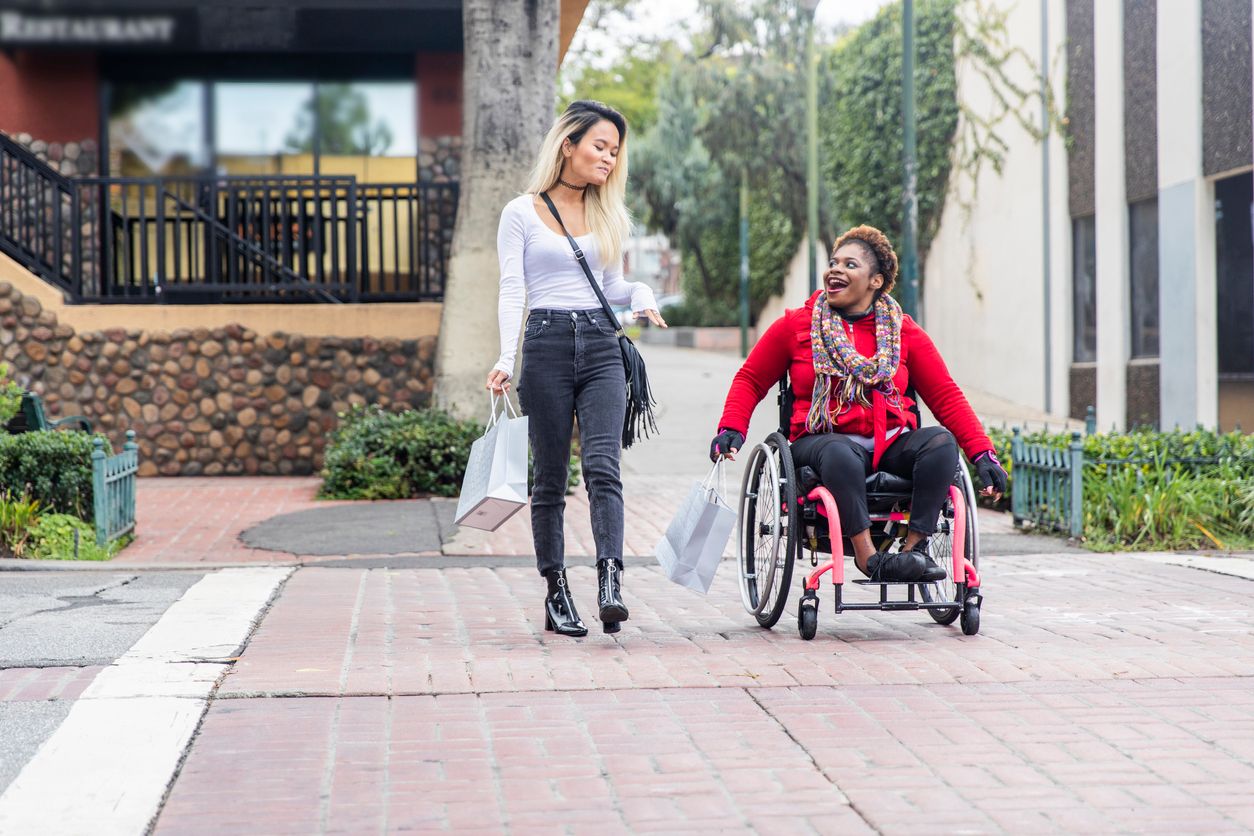 AA woman in wheelchair on a walk with a friend AA woman in wheelchair on a walk with a friend