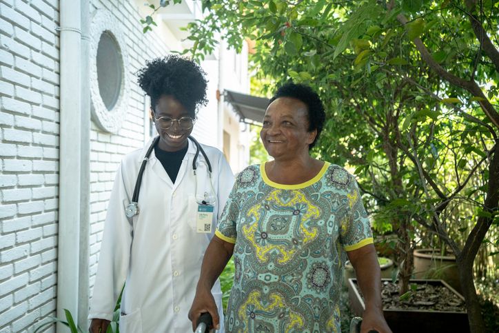 Healthcare worker helping an elderly lady