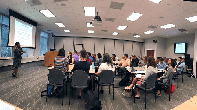 A classroom full of Presidential Management Fellows paying attention to a presentation.