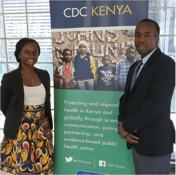 AdeSubomi Adeyemo, Class of 2017 Presidential Management Fellow, standing next to a CDC Kenya sign.