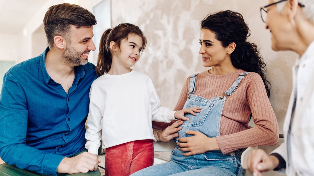 Expecting mom and family Family smiling at mom's pregnant belly