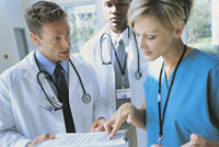 Doctors confer over a patient case file