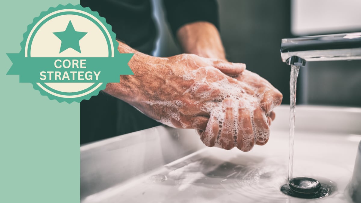 Hygiene Man soaping up his hands over a bathroom sink.