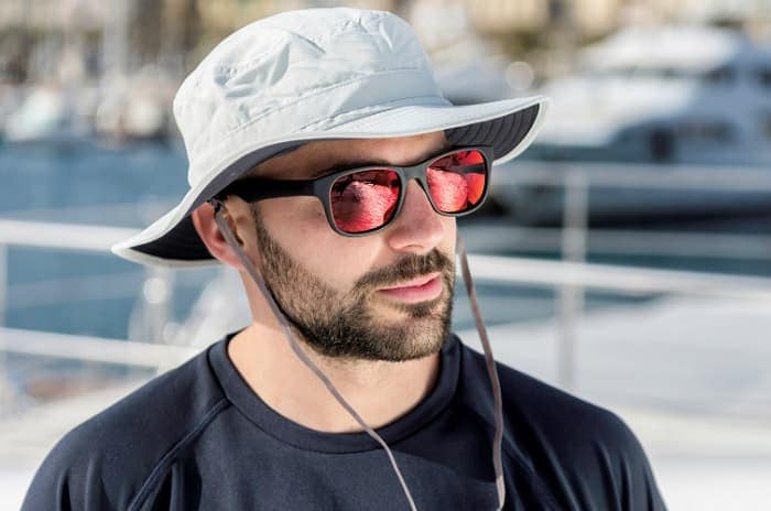Photo of a man wearing a hat and sunglasses