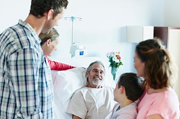 Foto de paciente de cáncer con familiares y amigos en el hospital.