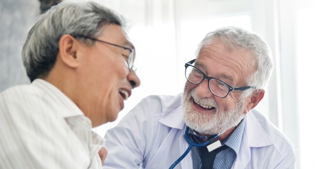 vacunas-adultos-650px.jpg Profesional de salud hablando con un paciente adulto sobre las vacunas.