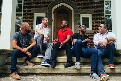 d_vs_inequidades-vih_113021 un grupo de hombres sentados en los escalones frente a un edificio