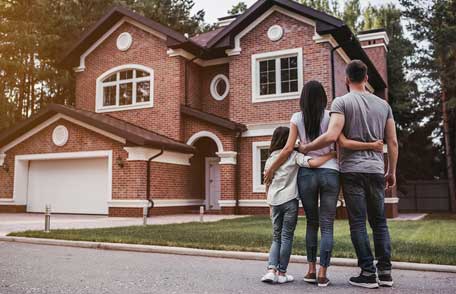 Una familia afuera de su nuevo hogar. Una familia afuera de su nuevo hogar.