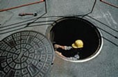 Trabajador que entra en una alcantarilla