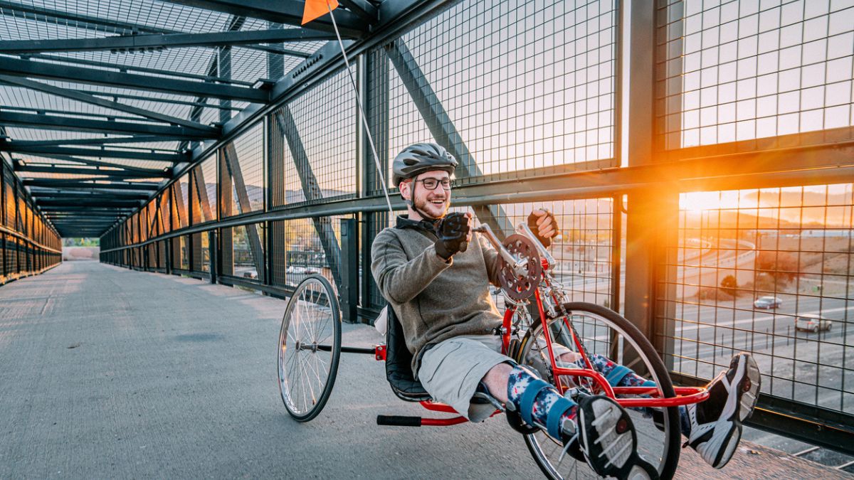 Young man with spina bifida riding on a handcycle exercising