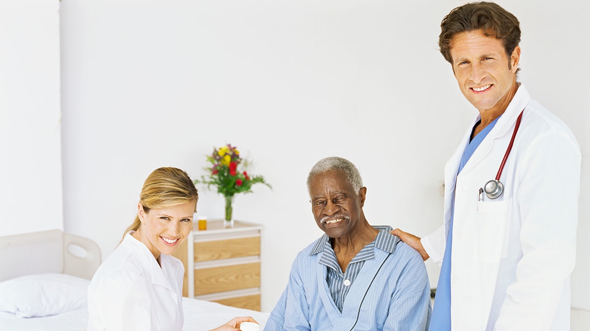 Doctor and nurse with older adult patient Doctor and nurse with older adult male patient