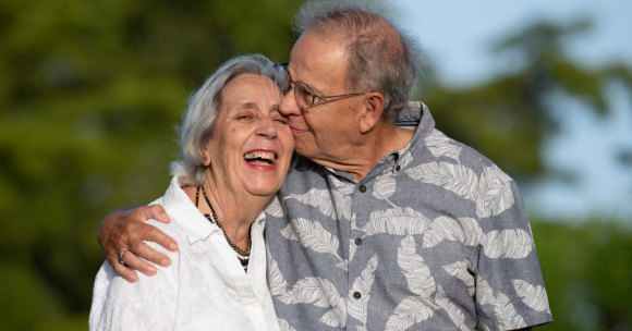 Older adult couple smiling and hugging