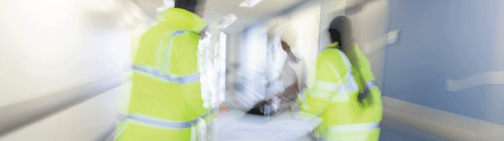 healthcare workers rushing down a hospital hall
