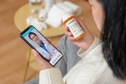 TB Notes 4 Woman reading prescription bottle while video chatting with doctor