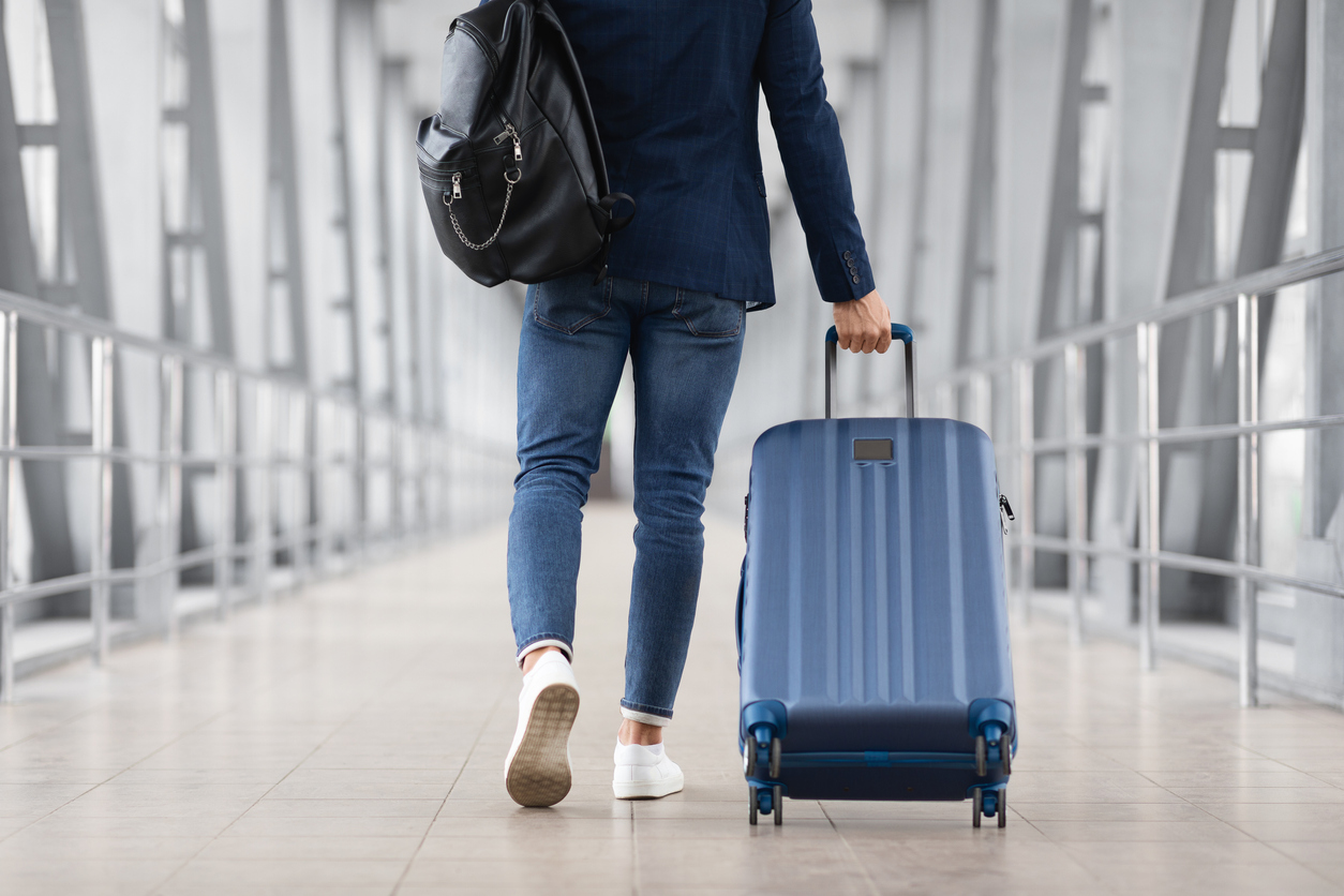 Airport luggage Man walking through airport pulling luggage