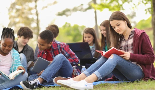 Multi-ethnic group of teenagers at park with friends.