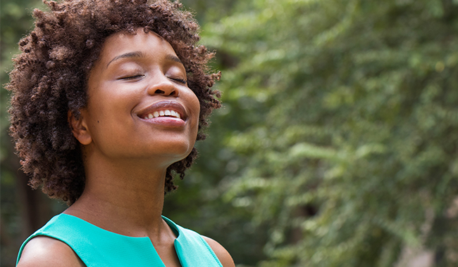 Joyful African American woman with eyes closed and head lifted