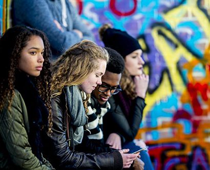 Teens looking at a phone.