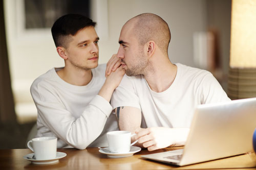 gay-couple-935471040-500x333 Guy couple at a table drinking coffee