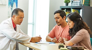 Provider explaining insurance to couple Provider explaining insurance to couple