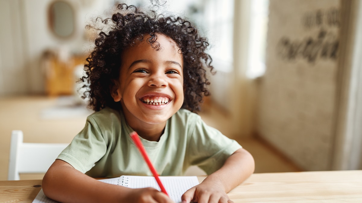 boy writing on notepad and smiling boy writing on notepad and smiling