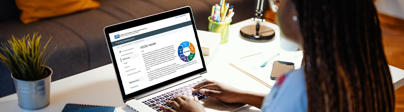 Training Development The ADDIE Model appears on the laptop of a woman working from home