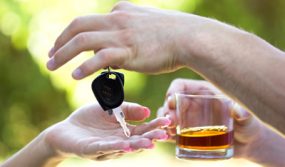 Photo: Man holding a drink handing over his car keys