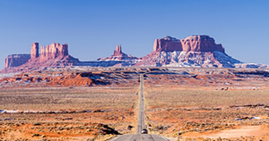 Car on highway approaching Monument Valley