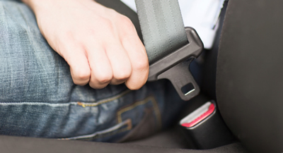 photo male close up seat belt - cropped horiz Close Up photo of a man buckling his seat belt