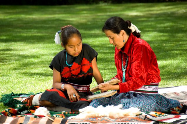 Two native Americans Learning how to weave