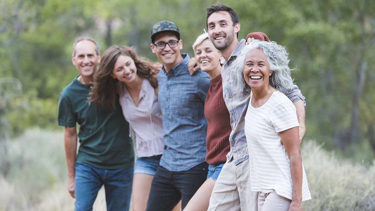 Un grupo de amigos abrazados y sonriendo hacia la cámara.