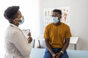 Médica hablando sobre las vacunas con un hombre joven