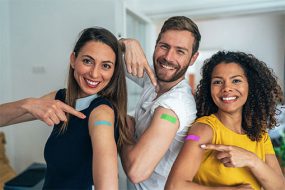 a group of adults showing arms after vaccination