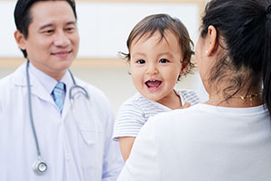 doctor-smiling-baby Male doctor talking to a mom with a baby.