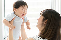Mother holding up smiling baby
