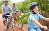 vaccine-safe young couple with son riding bikes