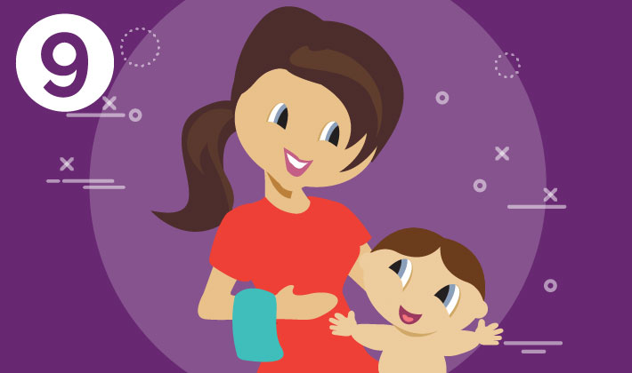 mother holding her baby on her left arm and a towel on her right arm