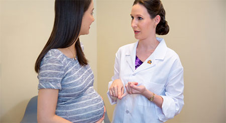 female-doctor-pregnant-patient female doctor talking with a pregnant patient