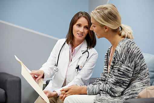 Médica mostrándole un informe médico a su paciente.
