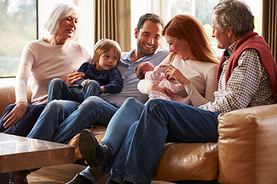 Multigeneration family sitting on sofa with newborn baby Multigeneration family sitting on sofa with newborn baby.